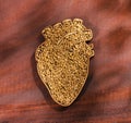 Fenugreek seeds in heart shaped bowl - Wood background