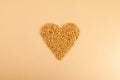 Fenugreek Seeds Methi Dana in heart shape on beige background. Shambhala or helba seeds is traditional Indian seasoning and