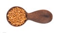 Fenugreek seeds in wooden spoon, isolated on white background. Shambala, helba seeds. Top view. Royalty Free Stock Photo