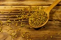 Fenugreek seeds in wooden spoon on wooden table Royalty Free Stock Photo