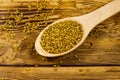 Fenugreek seeds in wooden spoon on wooden table Royalty Free Stock Photo