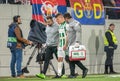 Ferencvaros midfielder David Siger escorted from the pitch by Ferencvaros doctors Gabor Leipzig and Laszlo Demeny after suffering