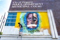 Ferguson, Missouri, USA, June 20, 2020 - artist painting black and white faces mural on Ferguson Missouri Police Station