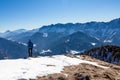 Ferlacher Horn - Man on panoramic hiking trail on way to snow covered mountain peak Ferlacher Horn in Carinthia