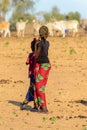 Unidentified Fulani girls in colored clothes stand on the stree