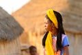 Unidentified Fulani woman with braids in yellow headscarf walks