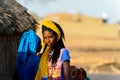 Unidentified Fulani woman in colored clothes walks along the st