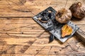 Fermented bulbs and cloves of black garlic. wooden background. Top view. Copy space Royalty Free Stock Photo