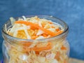 Fermented cabbage in a jar on a wooden table