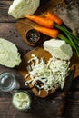 Fermented food. Prepare homemade sauerkraut jars with and carrot on rustic wooden table.