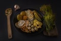 Fermented foods cabbage, peppers, pickles, tomatoes, mushrooms, zucchini, garlic in a black plate on a dark table Royalty Free Stock Photo