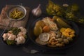 Fermented foods cabbage, peppers, pickles, tomatoes, mushrooms, zucchini, garlic in a black plate on a dark table Royalty Free Stock Photo