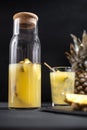 Fermented pineapple lemonade on a black background. Vertical frame