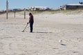 Fernandina Beach, Florida: A woman uses a metal detector to comb the sand