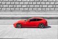 Ferrari F12 Berlinetta in Rosso Corsa Red - Color isolated in front of a building in black and white