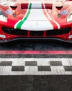 Ferrari racing touring car front detail on asphalt circuit starting line checkered sign marked on motorsport track Royalty Free Stock Photo