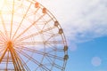 Ferris wheel against the blue sky and white clouds in the sun Royalty Free Stock Photo