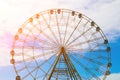 Ferris wheel against the blue sky and white clouds in the sun Royalty Free Stock Photo