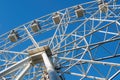 Ferris wheel on background of blue sky in sunny summer day