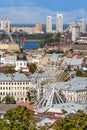 Ferris wheel and bell tower with copper roof and gilded dome in the old Podil district in Kyiv, cityscape on a summer day