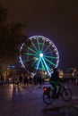 Cyclist passing in front of the Ferris wheel of Bellecour in Lyon Royalty Free Stock Photo