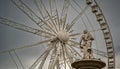 Ferris Wheel of Budapest and the top statue of Danubius Fountain in front of the cloudy sky