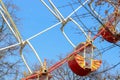 Ferris wheel in close up amusement park Colorful cabin on a background of blue bright clear sky. Branches of autumn