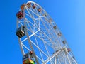 Ferris wheel, colorful cabins, clear blue sky