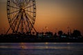 Ferris wheel and Georgian alphabet tower on orange sunset background. Royalty Free Stock Photo