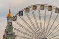 Ferris wheel in historical part of Kyiv. The bell tower of the former Greek monastery at the background