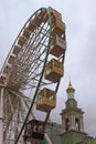 Ferris wheel in historical part of Kyiv. The bell tower of the Former Greek Monastery at the background Royalty Free Stock Photo