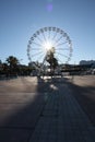 A ferris wheel L a Grande Roue in Old Port Cannes with the sun shining through with a wide view of the pavement Royalty Free Stock Photo