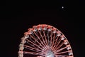 Ferris wheel and the moon. Black sky background. Royalty Free Stock Photo