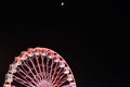 Ferris wheel and the moon. Black sky background. Royalty Free Stock Photo