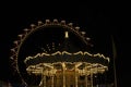 Ferris wheel at night, big wheel and carousel in lights Royalty Free Stock Photo