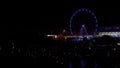 Ferris wheel at night. Blurry, colorful lights from an amusement park at night. Turning ferris wheel at night. Royalty Free Stock Photo