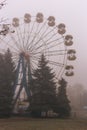 Ferris wheel in an old abandoned park in the autumn in thick fog Royalty Free Stock Photo