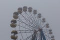 Ferris wheel in an old abandoned park in the autumn in thick fog Royalty Free Stock Photo