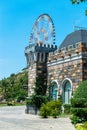 Ferris wheel over fairy castle with colorful walls in the amusement park