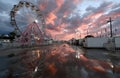 Ferris wheel reflecting in puddles at state fair during sunset Royalty Free Stock Photo