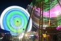 Ferris wheel and swing boat in a night market shot in long exposure (Surakarta, Indonesia-Oct 26, 2022)