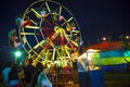 A Ferris Wheel veers by a big folk festival