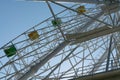 Ferris wheel with yellow and green booths against a blue sky Royalty Free Stock Photo