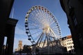 Ferriswheel in urban environment seen through shadows of buildings