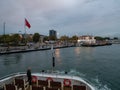 Ferry boat approaches to Kadikoy station. Cloudy fall rainy evening twilight outdoor shot