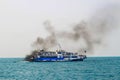 Ferry boat of Bay of Bengal smoke coming from its chimney. Black exhaust fumes coming from the chimney of a moored tanker.