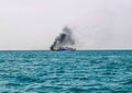 Ferry boat of Bay of Bengal smoke coming from its chimney. Black exhaust fumes coming from the chimney of a moored tanker.