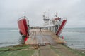 Ferry boat is loaded with cargo cars and tourist buses to cross Strait of Magellan at Punta Delgada into Tierra del Fuego island,