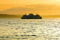 Ferry boat sailing across water at sunset Royalty Free Stock Photo