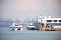 Ferry boats at a harbour with freight container ships in the backdrop Royalty Free Stock Photo